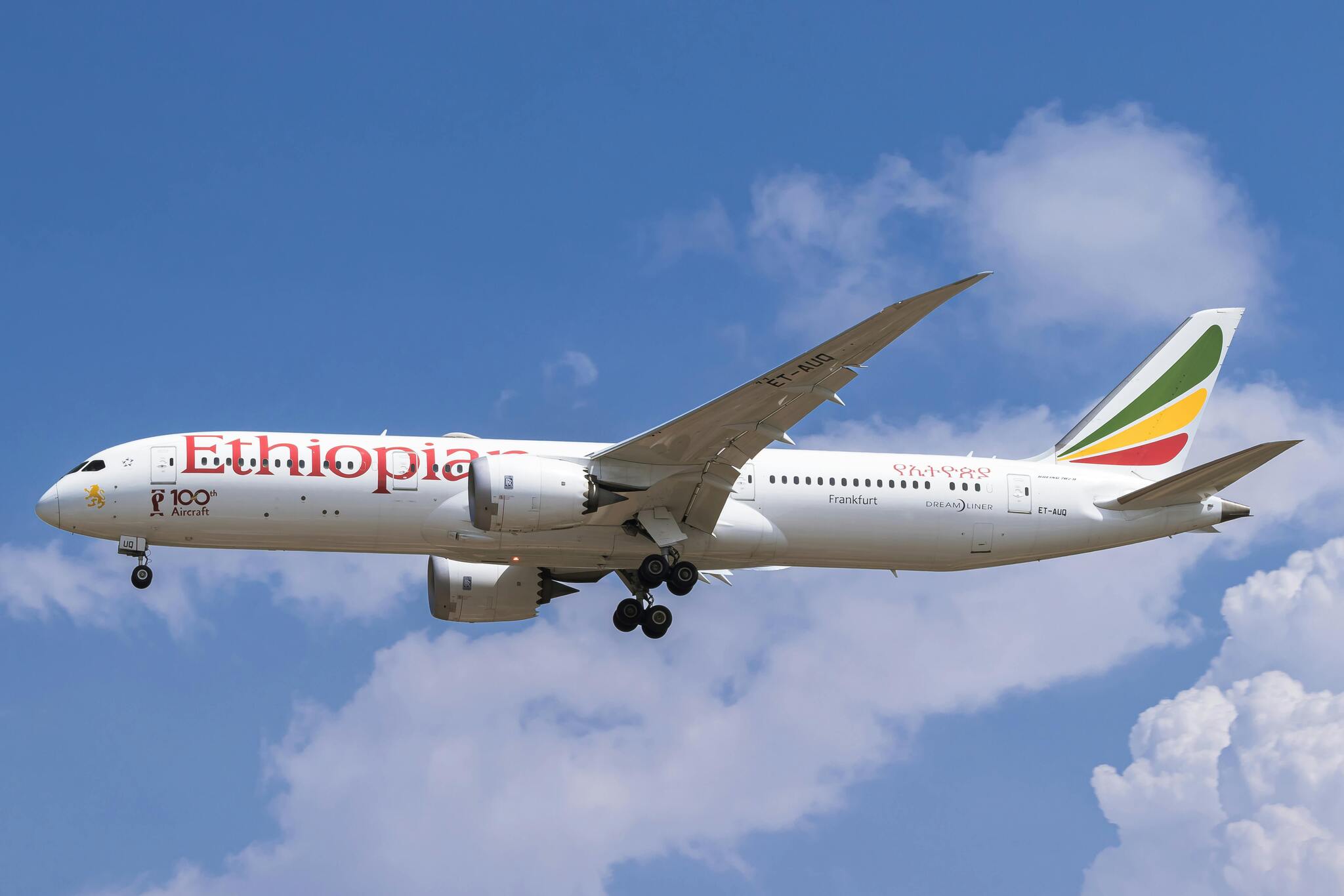 An Ethiopian Airlines Boeing 787 flying against a blue sky with clouds