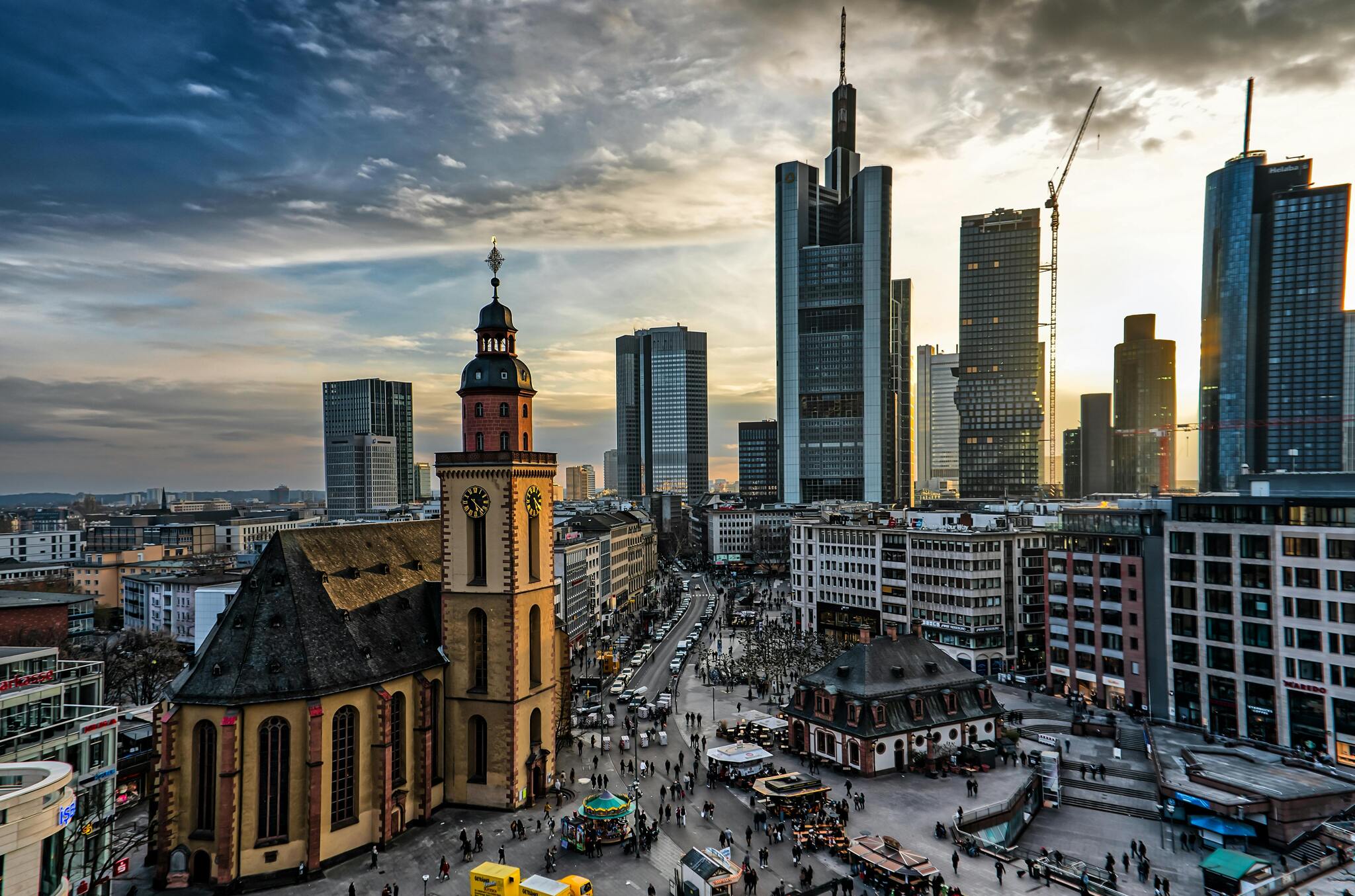 Frankfurt's skyscrapers rising behind a historic church at sunset