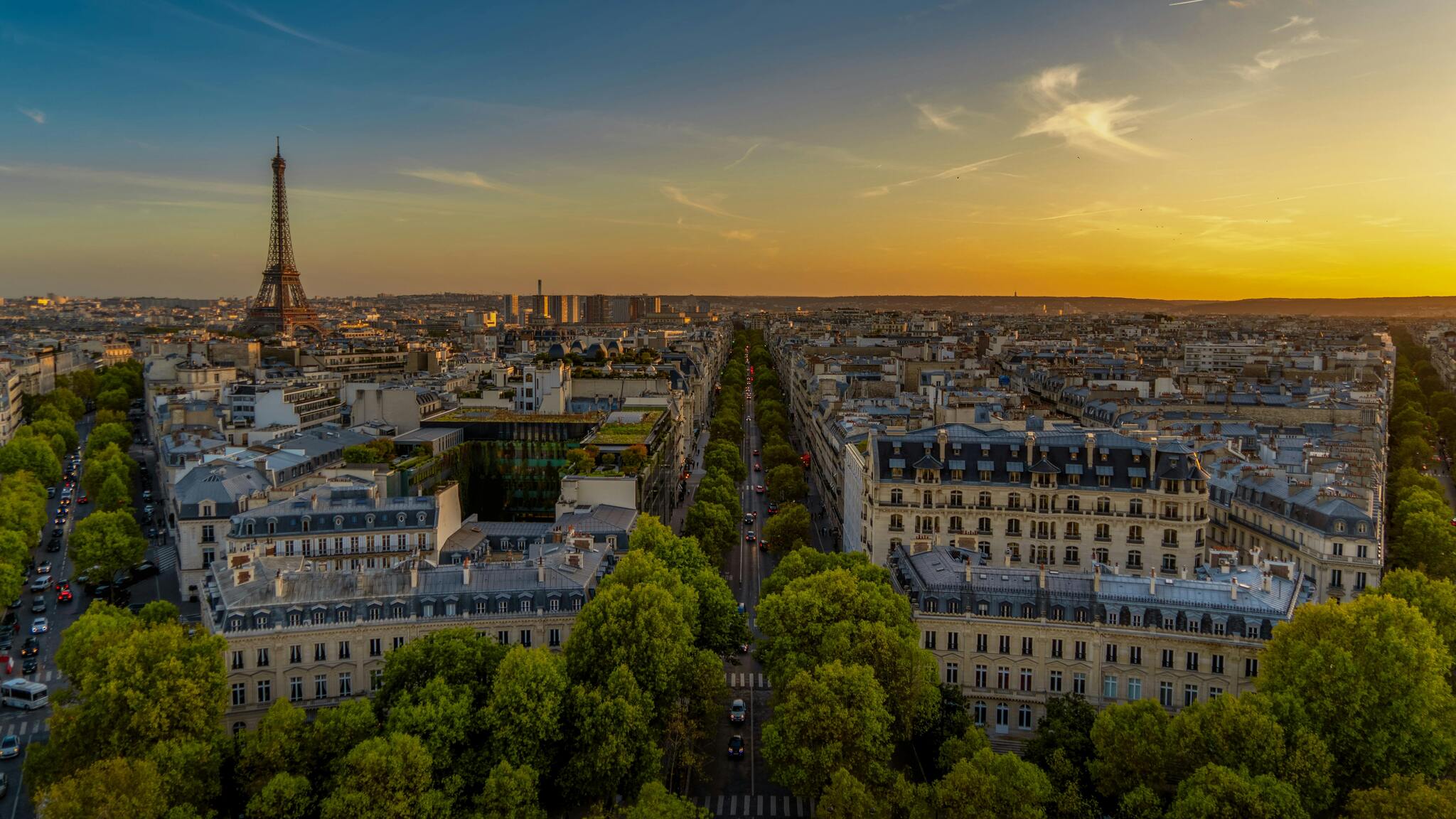 Aerial view of Paris at sunset, with the Eiffel Tower rising above the rooftops
