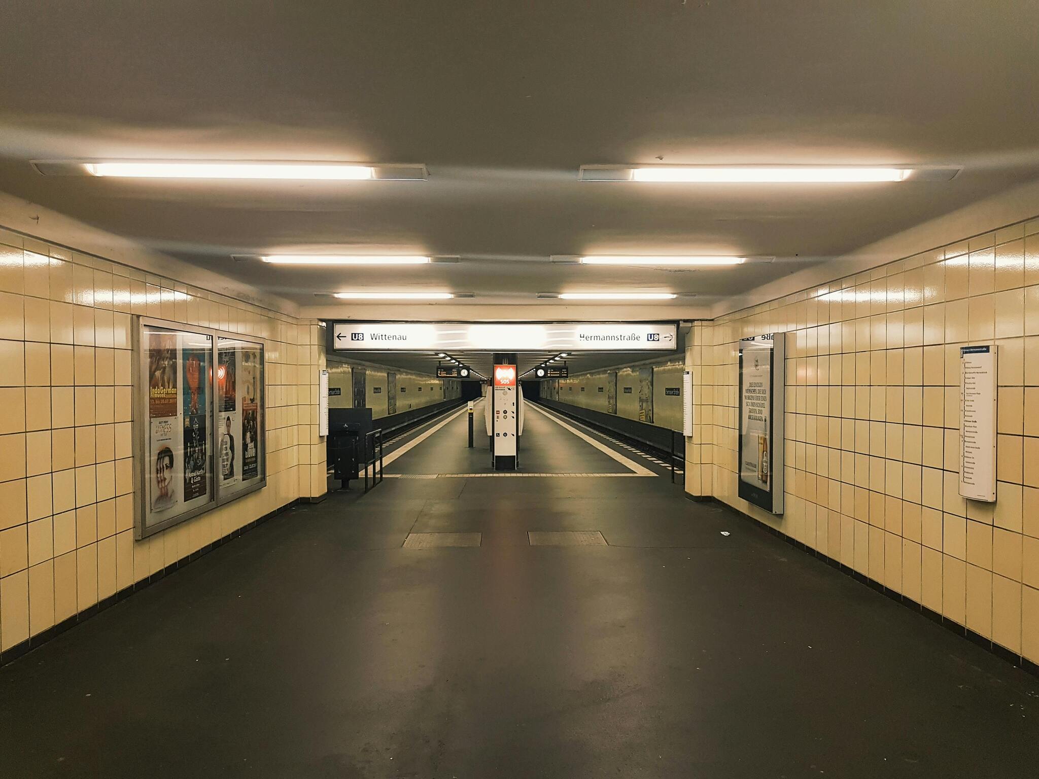 A brightly lit Berlin U-Bahn station hallway with yellow tiles
